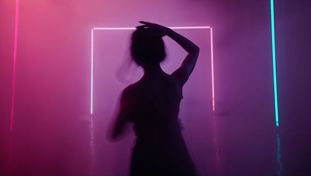 Silhouette of Dancer in Vibrant Neon Light Setup