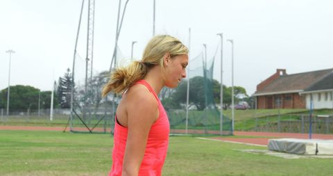 Female Athlete Preparing for Shot Put at Outdoor Stadium