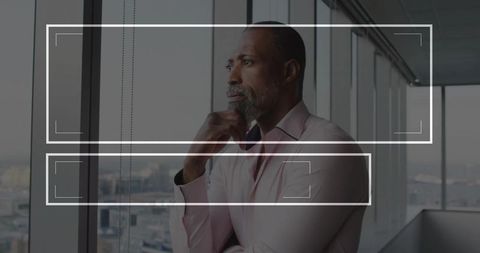 Thoughtful businessman gazing through large office window