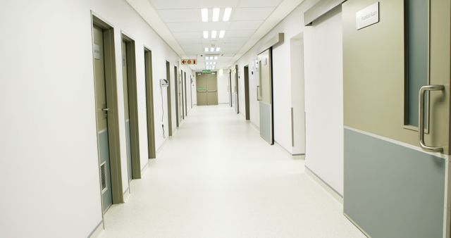 Depicts an empty hospital corridor with both open and closed doors, characterized by a clean and sterile environment. Ideal for use in articles, presentations, or advertisements related to medical facilities, healthcare industry, patient care, hospital architecture, and the importance of cleanliness and organization in medical settings.