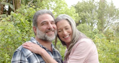 Happy Senior Couple Embracing in Green Backyard Garden