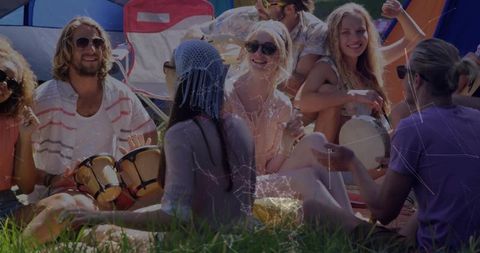 Friends Drumming Together at Outdoor Camping Site