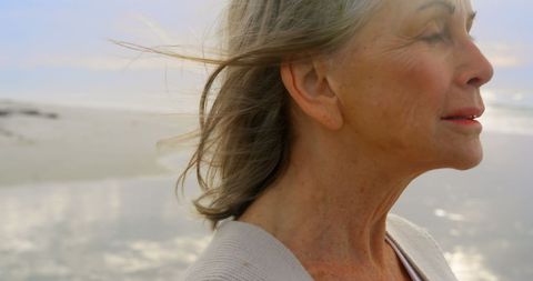 Senior Woman Enjoying Tranquil Beach View at Sunset - Download Free Stock Images Pikwizard.com