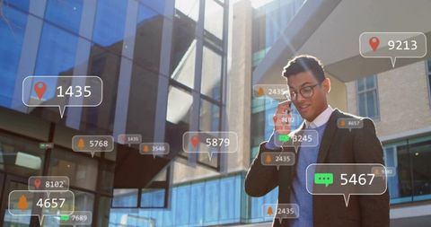 Businessman walking and taking phone call near glass office with augmented reality alerts