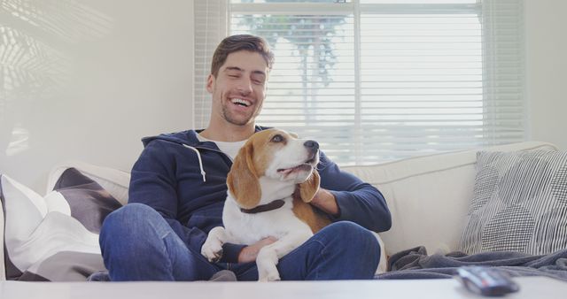 Smiling Young Man Relaxing on Couch with Beagle Dog - Download Free Stock Images Pikwizard.com