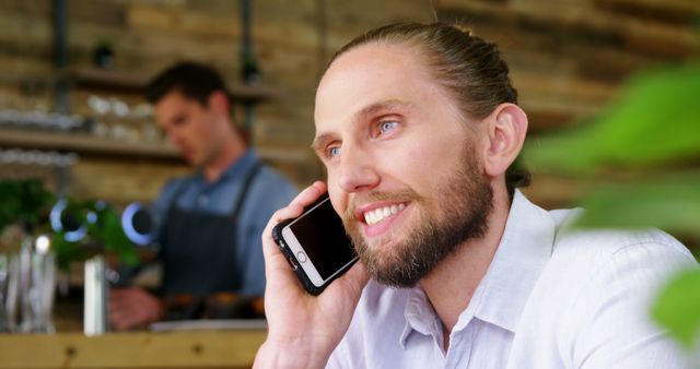 Man with Beard Having Phone Conversation in Cozy Cafe - Download Free Stock Images Pikwizard.com