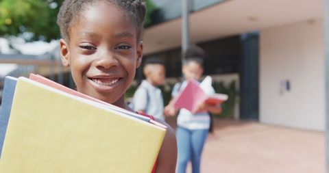Smiling African American Girl Holding Books Outdoors at School - Download Free Stock Images Pikwizard.com