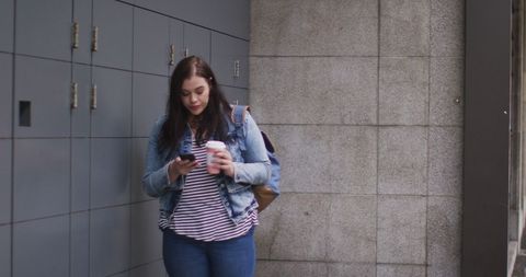 Young Plus Size Woman Walking in City Using Smartphone