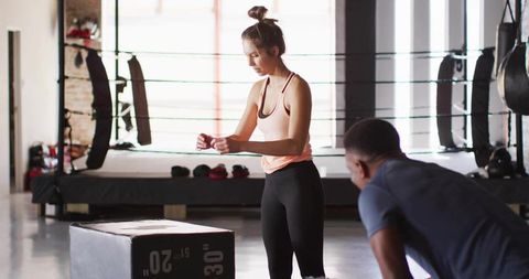 Coach guiding athlete through training session in gym