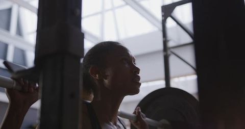 Determined Woman Weightlifting in Bright Industrial Gym