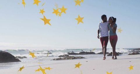 Walking barefoot on sunlit beach with golden star overlay, romantic couple embracing