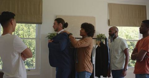 Friends Assisting Groom with Suit Before Wedding Ceremony at Home