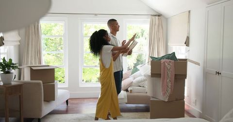 Diverse Couple Decorating New Home with Natural Light