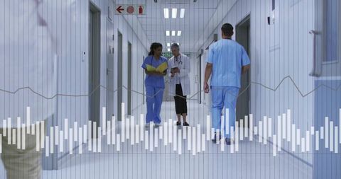 Medical team walking and discussing patient data in hospital corridor with tablet