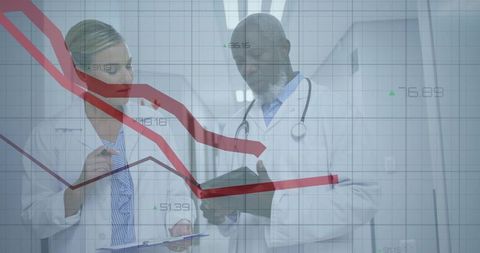 Doctors analyzing data with technology in hospital corridor