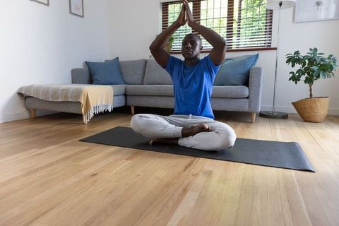 Man Practicing Yoga Meditating at Home
