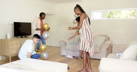 Friends preparing party decoration at home with balloons