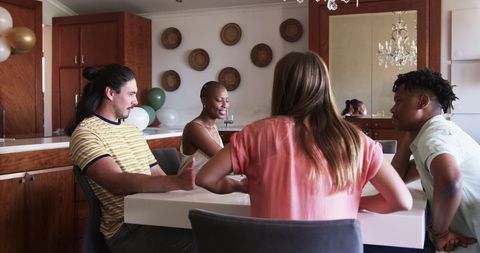 Friends Gather Around Dining Table for Social Meal Preparation