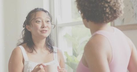 Sharing morning coffee beside sunny window, friendly conversation between friends at home