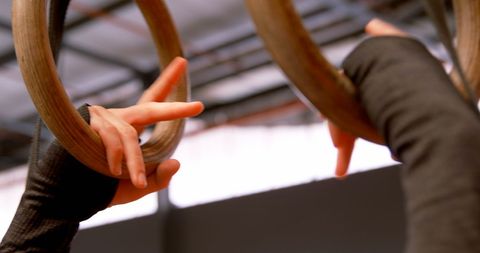 Woman Gripping Gymnastic Rings in Fitness Studio