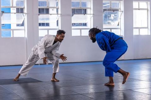 Martial arts training african american men sparring in dojo