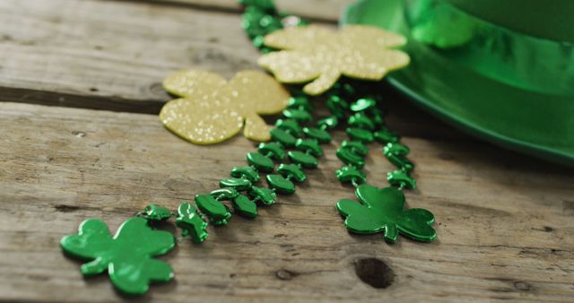 Close-up capturing festive decorations for St. Patrick's Day, including sparkling clover-shaped beads and a vibrant green hat placed on a rustic wooden table. Ideal for use in blogs, social media posts, holiday promotions, or event-planning materials focusing on St. Patrick's Day celebrations.