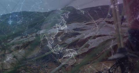 Technician adjusting tripod on rocky hill with digital globe overlay