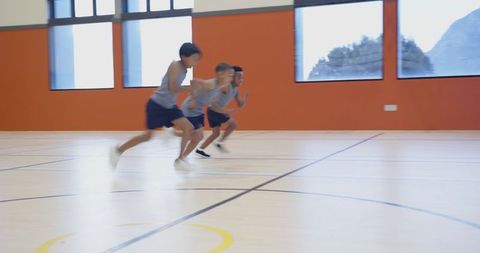 Energetic boys sprinting across school gym