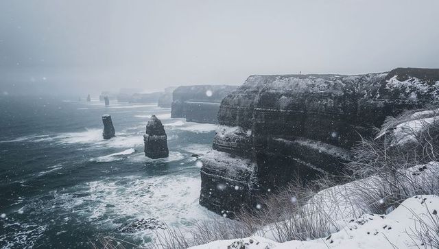 Snow-Dusted Sea Cliffs and Offshore Sea Stacks Facing Turbulent Winter Storm Surf
