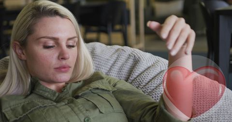 Intern resting on couch with sore elbow in casual green shirt