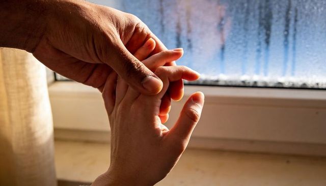 Holding child hand at fogged window offering comfort and warmth, parent bond