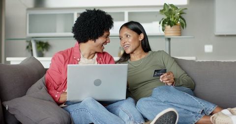 Happy Couple Shopping Online at Home with Laptop and Credit Card