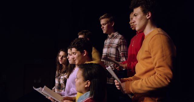 Young actors rehearsing on stage with scripts under spotlight - Download Free Stock Images Pikwizard.com