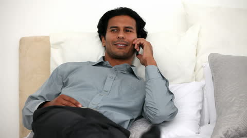 Relaxed Professional Man Having Phone Call on Bed