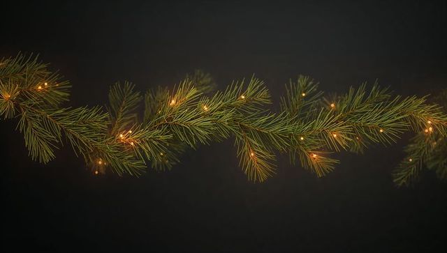 Glowing pine garland with warm fairy lights on dark backdrop for festive minimalist design