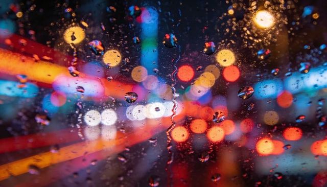 Rainy City Night Showing Neon Bokeh Through Wet Windshield With Traffic Light Trails