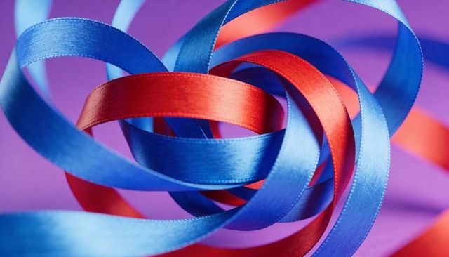 Intertwining satin ribbons twisting and gleaming in red and blue against purple-pink backdrop