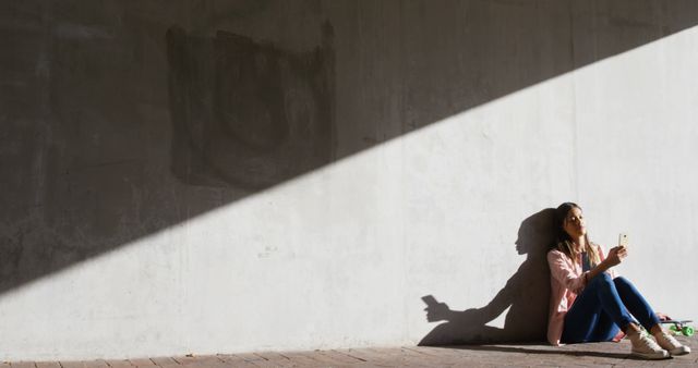 Woman Sitting Under Harsh Sunlight on Street, Using Smartphone - Download Free Stock Images Pikwizard.com