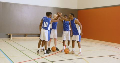 Diverse basketball team in group huddle demonstrating unity and motivation