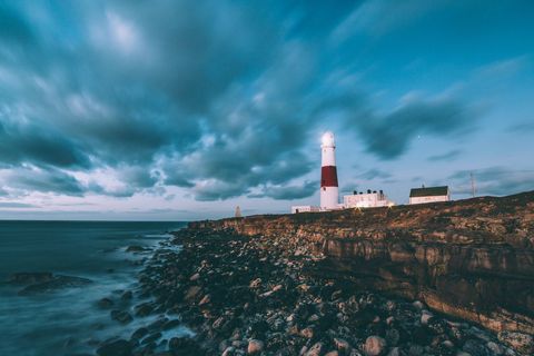 Majestic Lighthouse on Rocky Coastline at Dusk