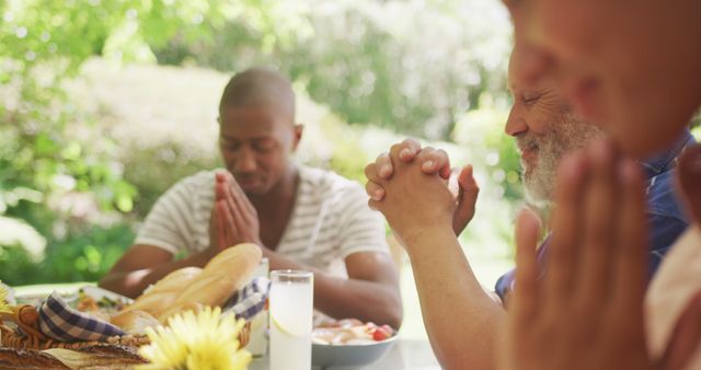 Family Members Praying Before Meal at Outdoor Table During Sunny Day - Download Free Stock Images Pikwizard.com