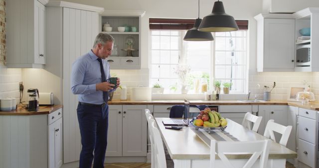 Businessman in Contemporary Kitchen Using Tablet and Drinking Coffee - Download Free Stock Images Pikwizard.com