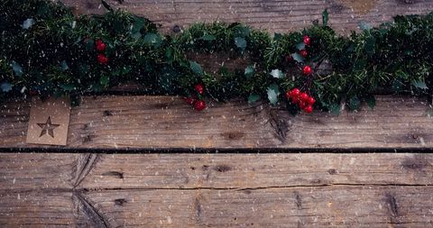 Festive Christmas Garland on Rustic Wooden Boards with Falling Snow - Download Free Stock Images Pikwizard.com
