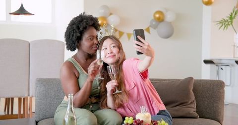 Joyful multicultural couple celebrating with champagne at home party