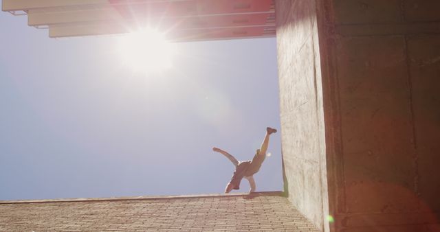 Urban Freerunner Performing Wall Flip Against Sunlit Sky - Download Free Stock Images Pikwizard.com