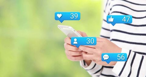 Tapping smartphone receiving social notifications showing likes comments followers