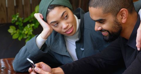 Happy Couple Browsing Smartphone in Urban Cafe Scene