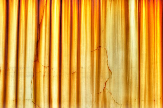 Vintage yellow curtain with visible cracks and dramatic lighting, perfect for backgrounds, textures, theatrical themes, or nostalgic vintage projects. Ideal for adding an aged or historical feel to art pieces, digital artwork, and design projects.