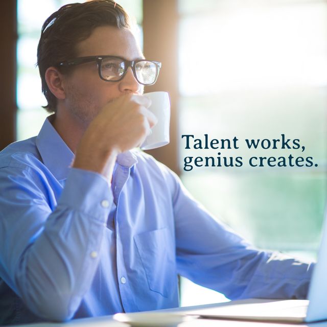 A professional man in a blue shirt and glasses is sipping coffee while working at his desk. The background is softly lit, creating a serene and focused atmosphere. The quote 'Talent works, genius creates' adds a motivational element. Ideal for use in blogs, promotional materials, business presentations, or inspirational content aimed at professionals seeking daily motivation.