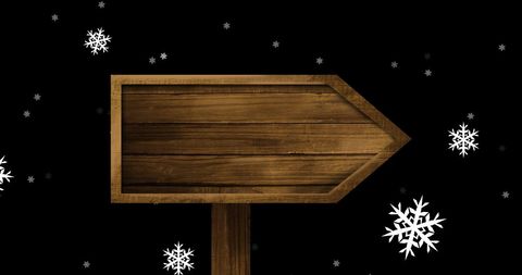 Wooden Signboard with Snowflakes Against Black Background